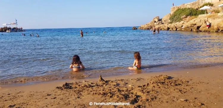 2 små jenter sitter å leker i vannkanten på Denizkizi Beach club Alsancak